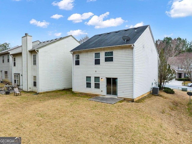 rear view of property featuring a lawn and central air condition unit