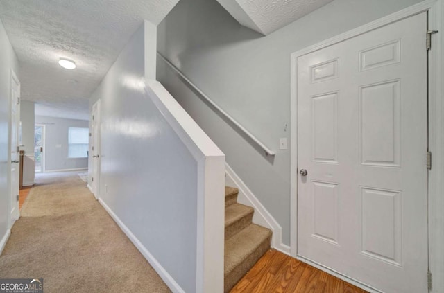 stairway featuring hardwood / wood-style floors and a textured ceiling