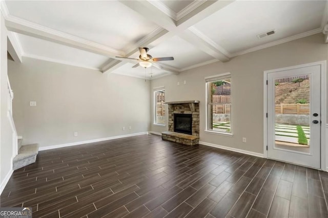 unfurnished living room with ornamental molding, coffered ceiling, ceiling fan, beam ceiling, and a stone fireplace