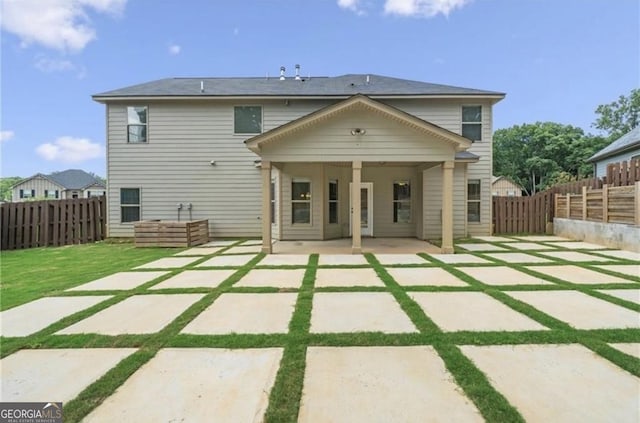 rear view of property with a yard and a patio