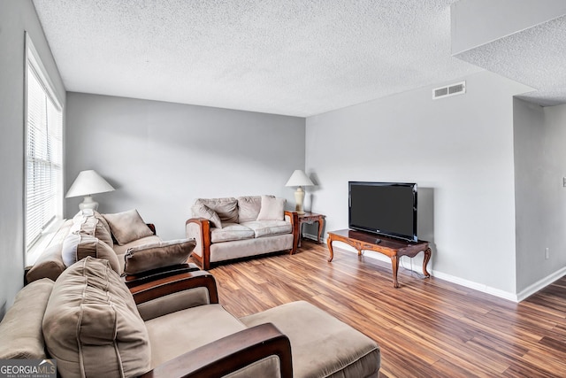 living room featuring hardwood / wood-style floors and a textured ceiling