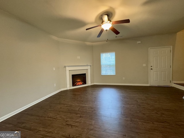 unfurnished living room with ceiling fan and dark wood-type flooring