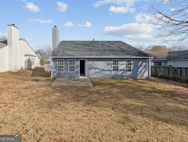 rear view of house featuring a patio and a yard