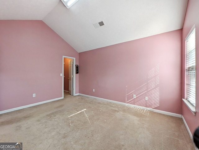 carpeted spare room with lofted ceiling