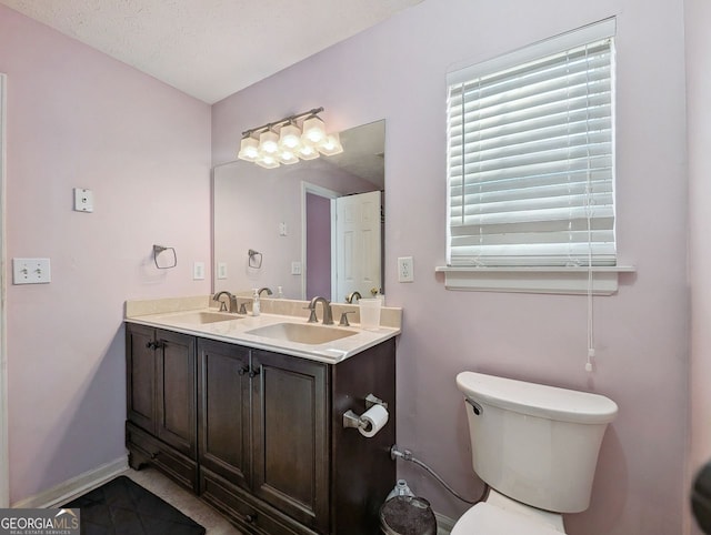 bathroom featuring toilet, tile patterned flooring, vanity, and a textured ceiling