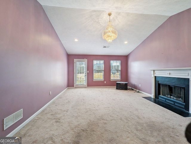 unfurnished living room featuring lofted ceiling, a textured ceiling, an inviting chandelier, and carpet