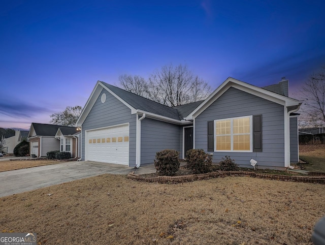 ranch-style home featuring a garage and a lawn