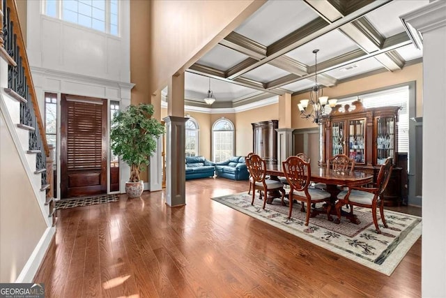 dining room with an inviting chandelier, coffered ceiling, hardwood / wood-style flooring, ornamental molding, and beamed ceiling