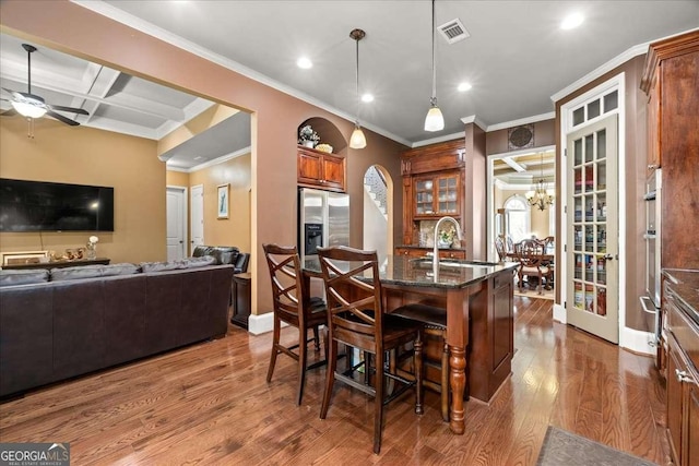 dining area with coffered ceiling, ceiling fan with notable chandelier, sink, dark hardwood / wood-style floors, and beam ceiling