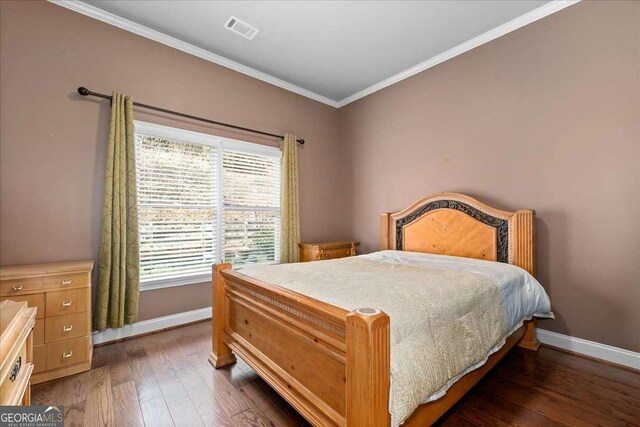 bedroom with ornamental molding and dark wood-type flooring