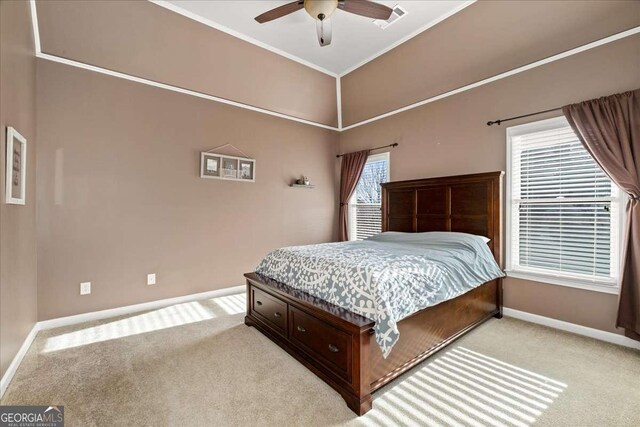 carpeted bedroom with ceiling fan and crown molding