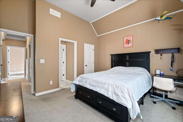 bedroom featuring light carpet, ornamental molding, ceiling fan, and lofted ceiling