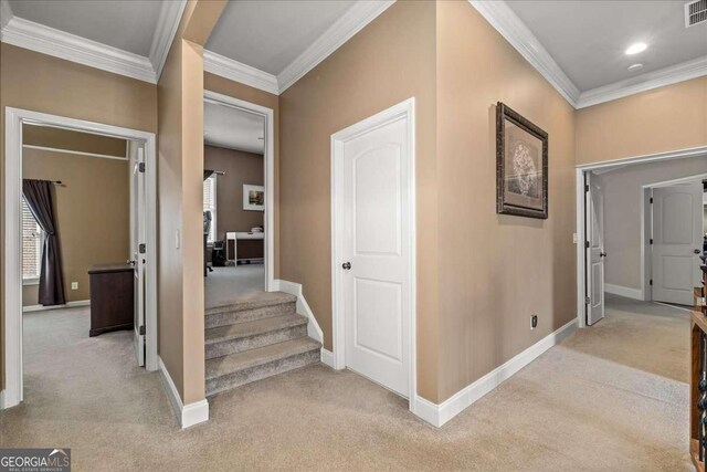 hall with light colored carpet and ornamental molding