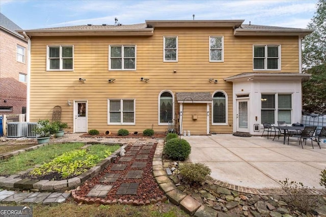 rear view of property featuring a patio and central AC