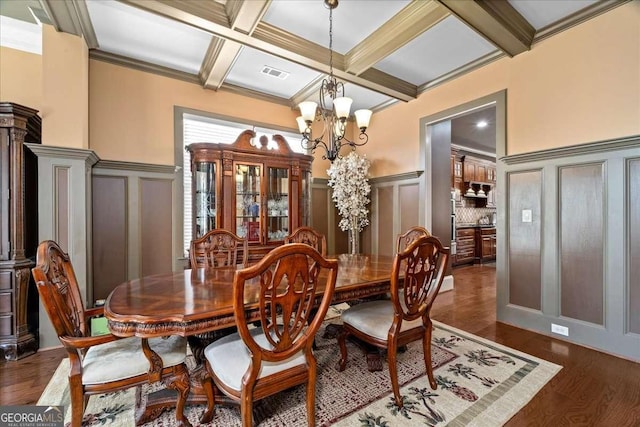 dining room featuring crown molding, coffered ceiling, and a notable chandelier