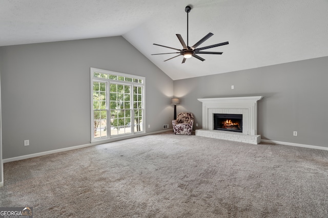 unfurnished living room with ceiling fan, carpet floors, a textured ceiling, lofted ceiling, and a fireplace