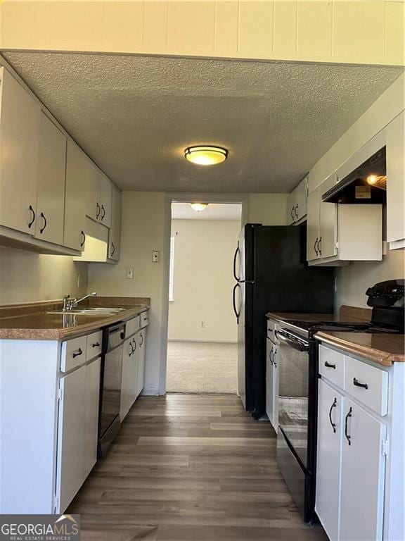 kitchen with black appliances, sink, and white cabinets