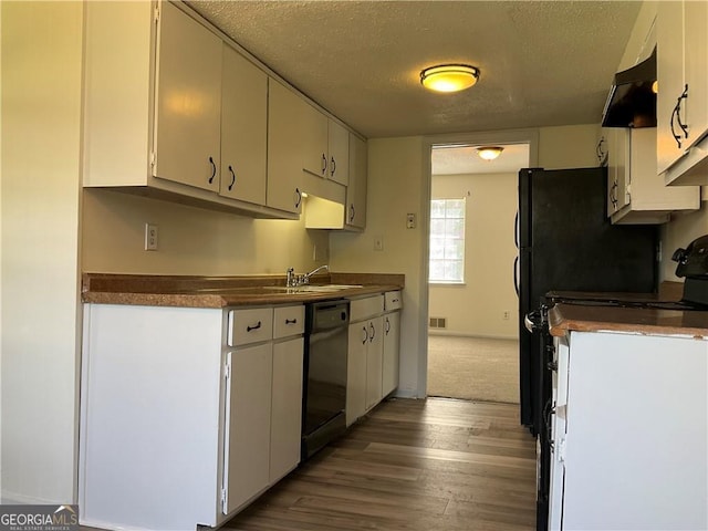 kitchen with black dishwasher and white cabinets