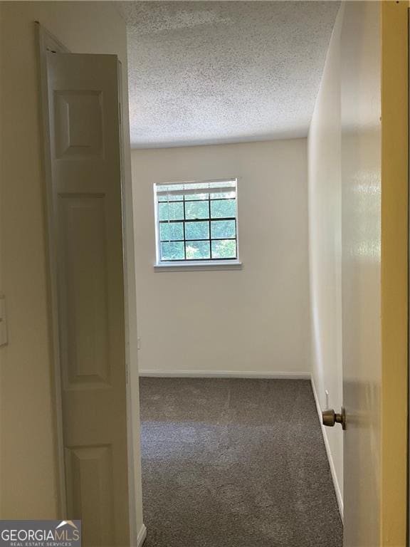 carpeted spare room with a textured ceiling