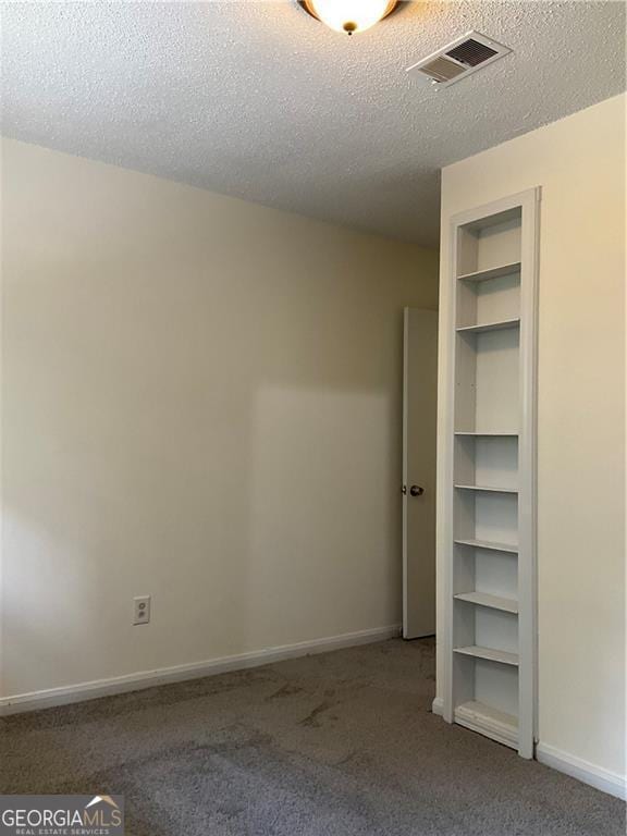 unfurnished bedroom with carpet floors and a textured ceiling