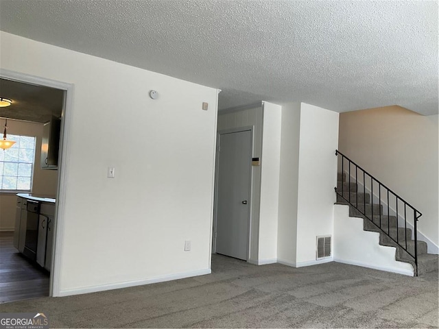 spare room with carpet flooring and a textured ceiling