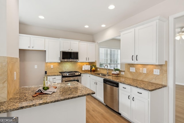 kitchen featuring sink, white cabinets, dark stone counters, and appliances with stainless steel finishes