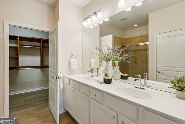 bathroom featuring a shower with door, vanity, and hardwood / wood-style flooring