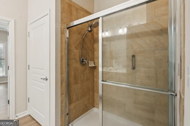 bathroom with walk in shower and hardwood / wood-style floors