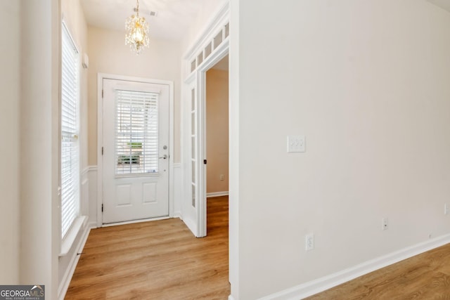 entryway featuring light wood-type flooring and a notable chandelier