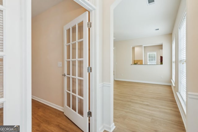 hall featuring french doors and light hardwood / wood-style floors