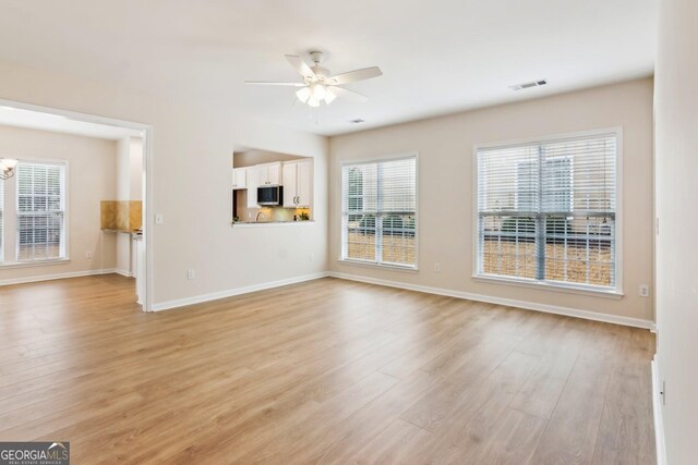 unfurnished living room with ceiling fan and light hardwood / wood-style floors