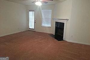 unfurnished living room with ceiling fan