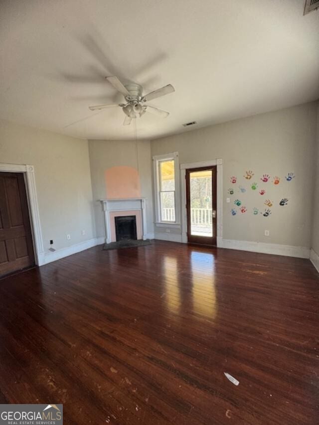 unfurnished living room featuring dark hardwood / wood-style floors and ceiling fan