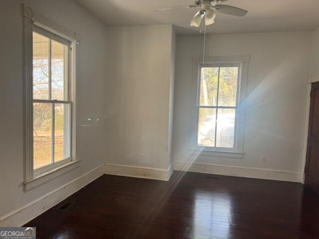 unfurnished room featuring ceiling fan and dark wood-type flooring