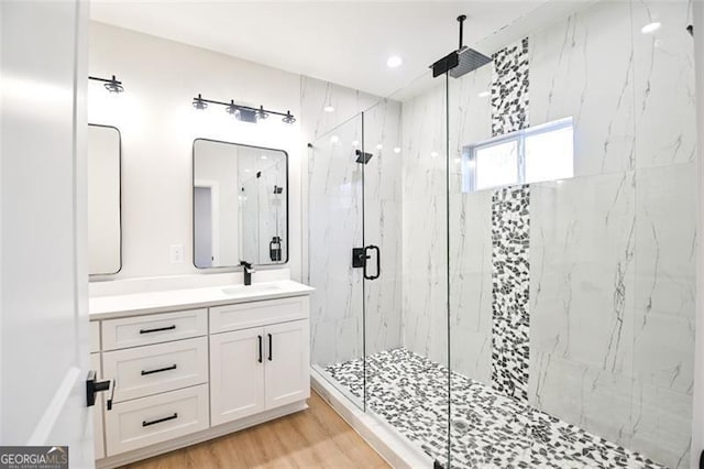 bathroom with a shower with shower door, wood-type flooring, and vanity