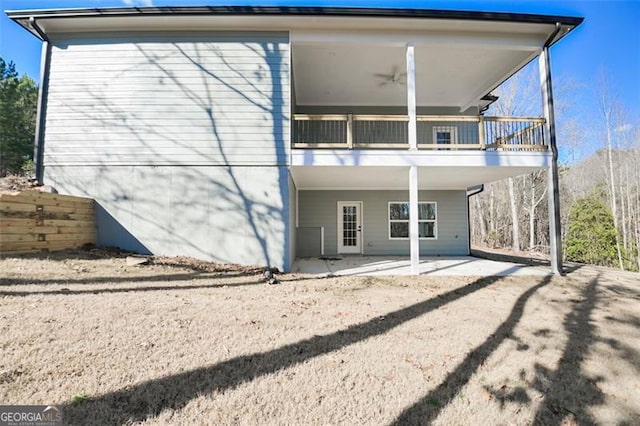 rear view of property with a patio area, ceiling fan, and a balcony