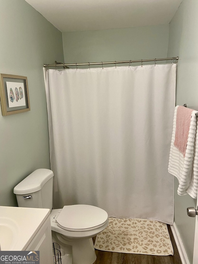 bathroom with hardwood / wood-style flooring, vanity, toilet, and a shower with curtain