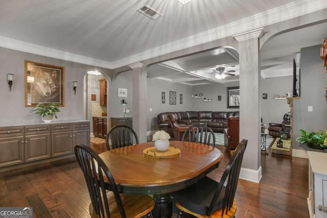 dining room with decorative columns, crown molding, ceiling fan, and dark wood-type flooring