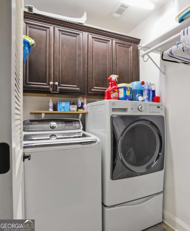 laundry area with washer and dryer and cabinets