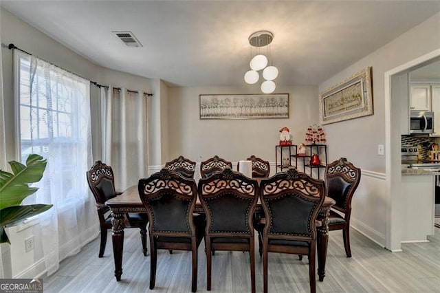 dining room featuring light hardwood / wood-style floors and an inviting chandelier