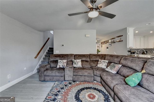 living room with ceiling fan, sink, and light hardwood / wood-style floors