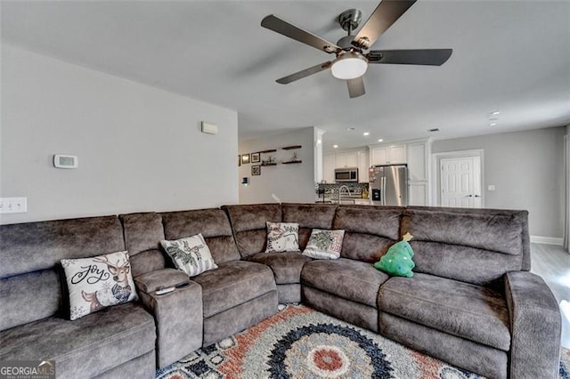 living room featuring light hardwood / wood-style flooring and ceiling fan