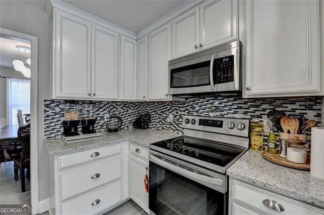 kitchen with decorative backsplash, light stone countertops, white cabinetry, and appliances with stainless steel finishes