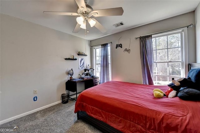 carpeted bedroom featuring multiple windows and ceiling fan