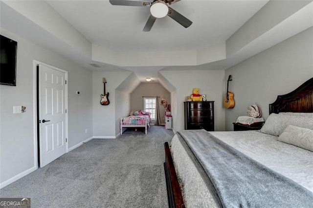 bedroom featuring carpet flooring, a raised ceiling, and ceiling fan