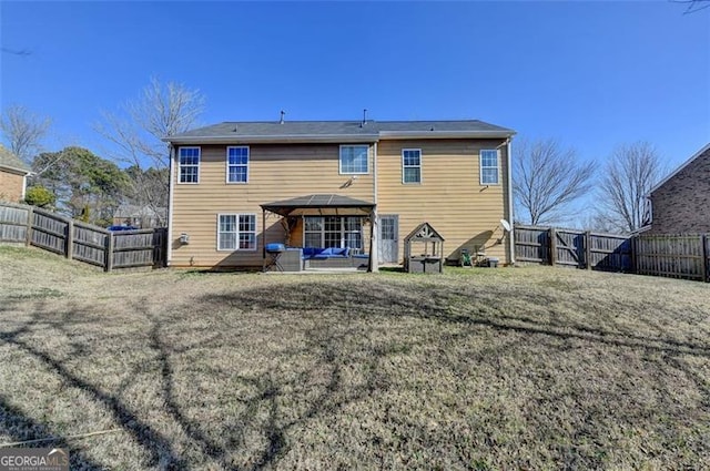 back of property with a gazebo and a yard