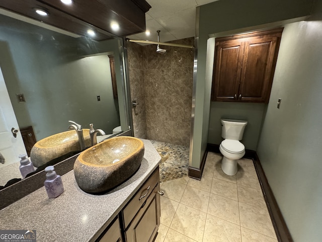 bathroom featuring tile patterned flooring, vanity, an enclosed shower, and toilet