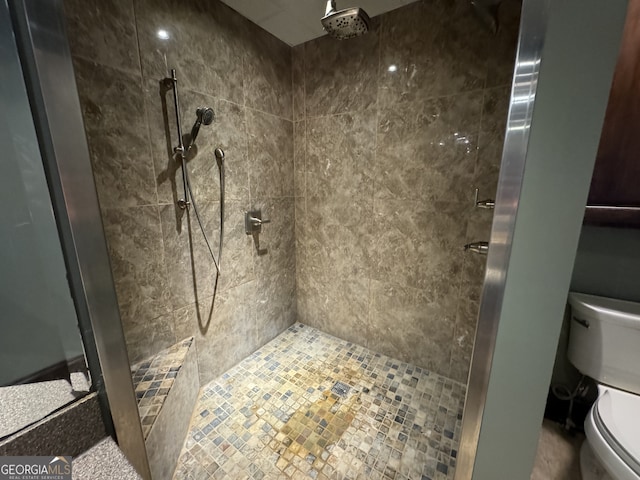 bathroom featuring toilet and tiled shower