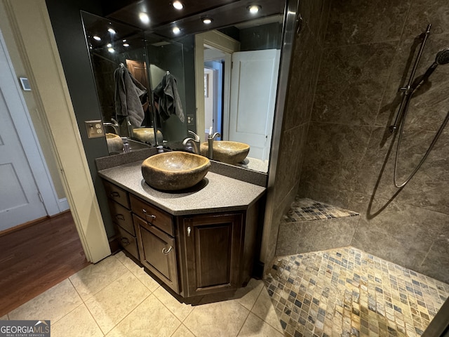 bathroom featuring tiled shower, vanity, and tile patterned floors