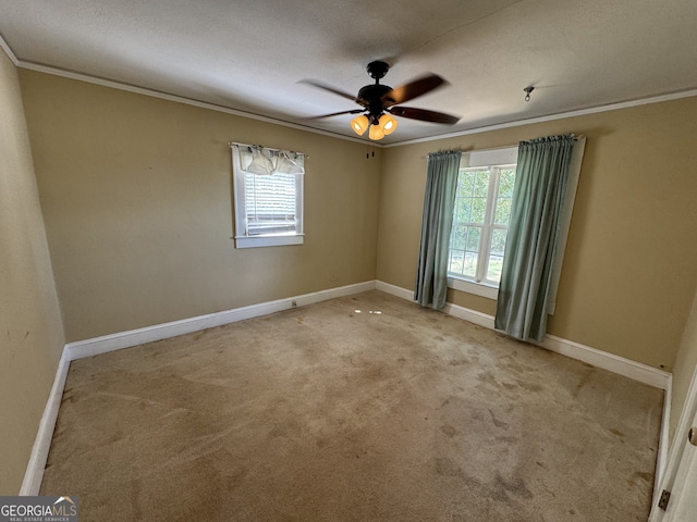 spare room featuring ceiling fan, ornamental molding, light carpet, and a wealth of natural light